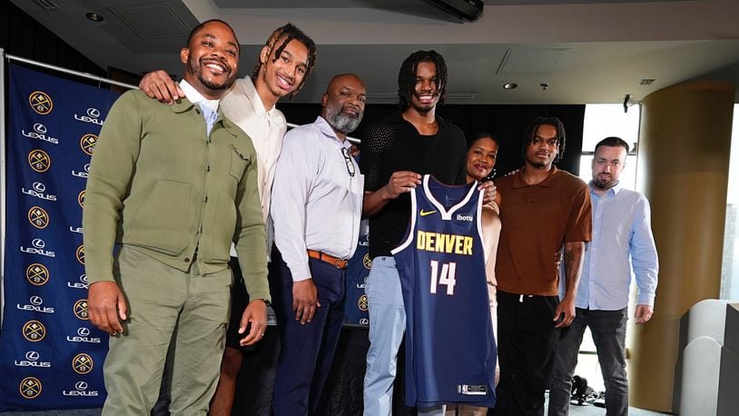 Denver Nuggets 2024 first-round draft pick DaRon Holmes II, center, holds up his jersey for a photograph with, from left, business manager Mitch Brown, brother Cameron Holmes, father DaRon, Sr., mother Tomika, brother Quintyn and agent Aaron Reilly during an NBA basketball news conference Monday, July 1, 2024, in Denver. (AP Photo/David Zalubowski)