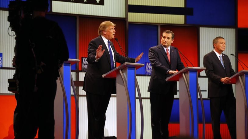 Republican presidential candidates, businessman Donald Trump, and Sen. Ted Cruz, R-Texas, argue as Ohio Gov. John Kasich listens during a Republican presidential primary debate at Fox Theatre, Thursday, March 3, 2016, in Detroit. (AP Photo/Paul Sancya)