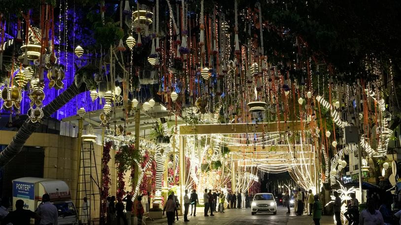 FILE - People walk past the Antilia mansion, house of billionaire Mukesh Ambani, while it is lit up ahead of his son Anant Ambani and Radhika Merchant's wedding in Mumbai, India, Wednesday, July 10, 2024. The youngest son of Mukesh Ambani, Asia’s richest man, has married his longtime girlfriend in what many have dubbed the wedding of the year. The wedding early Saturday was being attended by global celebrities, business tycoons and politicians, highlighting the billionaire’s staggering wealth and rising clout, and came after months of festivities.(AP Photo/Rajanish Kakade, File)