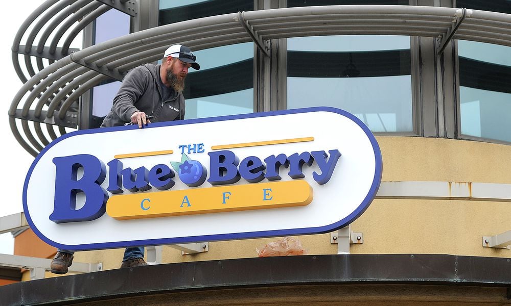 Marc Robinson of Wilcon Construction places The Blue Berry Cafe sign on the old Golden Nuggent Pancake House in Kettering Wednesday, Jan. 3, 2024. MARSHALL GORBY\STAFF