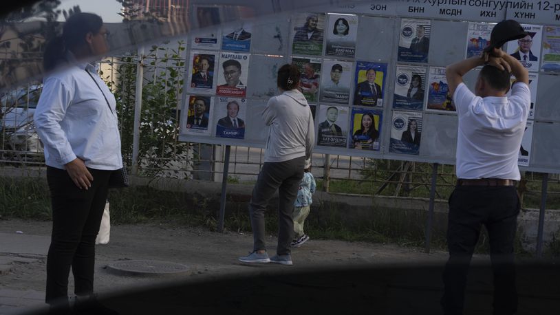 Residents look at election posters of candidates, two days before polls open in Ulaanbaatar, Mongolia, June 26, 2024. As a democracy of just 3.4 million people in the shadow of two much larger authoritarian states, China and Russia, it has taken on symbolic importance in an era when democracy is under pressure or in crisis in many countries, including the United States. (AP Photo/Ng Han Guan)