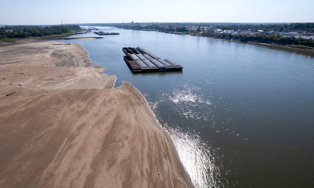 FILE - Barges float in the Mississippi River as a portion of the riverbed is exposed, on Sept. 15, 2023, in St. Louis. The U.N. weather agency is reporting that 2023 was the driest year in more than three decades for the world's rivers, as the record-hot year underpinned a drying up of water flows and contributed to prolonged droughts in some places. (AP Photo/Jeff Roberson, File)