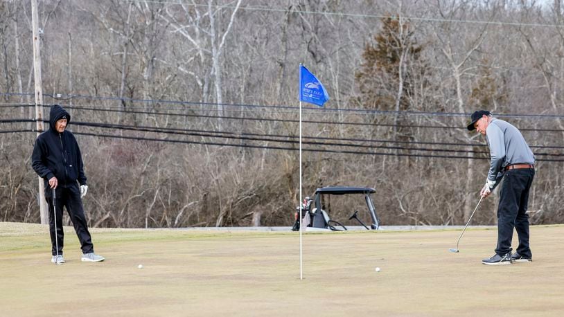 Jim Warren, left, watches as Randy Kleine putts on the green of hole 18 at Potter's Park Golf Course Thursday, Feb. 1, 2024 in Hamilton. NICK GRAHAM/STAFF