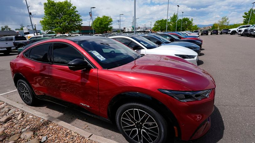 FILE - A line of unsold 2024 Mustang Mach-E electric utility vehicles sit at a Ford dealership May 19, 2024, in Denver. On Tuesday, July 2, 2024, automakers will report second-quarter U.S. sales and they're expected to be flat compared with a year ago. (AP Photo/David Zalubowski, File)