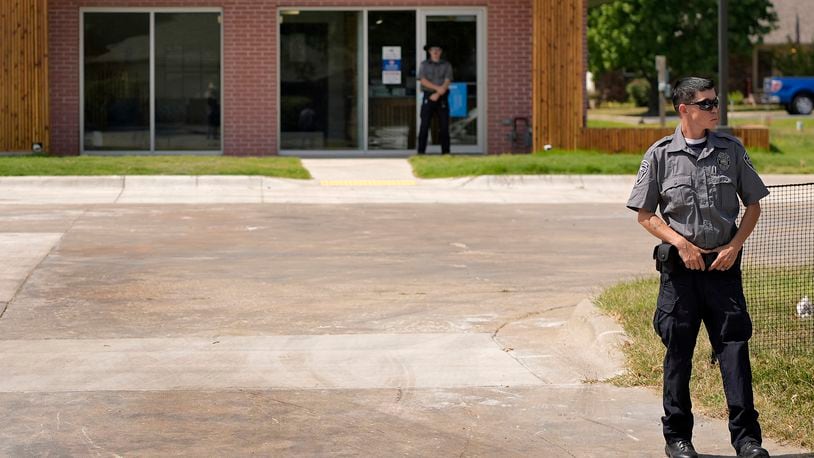 Security personnel stand outside a recently opened Planned Parenthood clinic, Tuesday, Sept. 10, 2024, in Pittsburg, Kan. (AP Photo/Charlie Riedel)