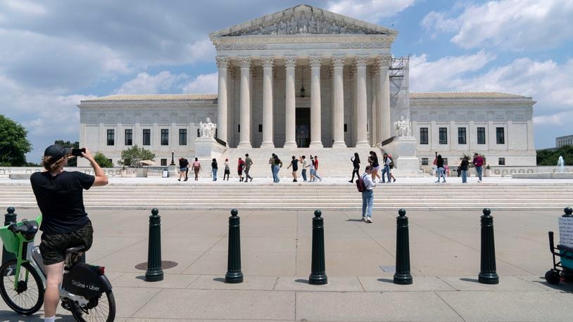 Visitors pose for photographs at the U.S. Supreme Court Tuesday, June 18, 2024, in Washington. ( AP Photo/Jose Luis Magana)