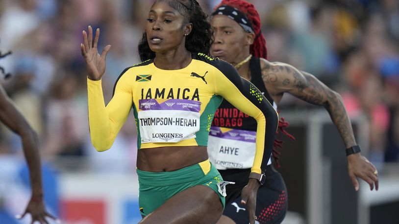 FILE - Jamaica's Elaine Thompson-Herah, center, races to win a women's 100m semifinal during the athletics in the Alexander Stadium at the Commonwealth Games in Birmingham, England, Wednesday, Aug. 3, 2022. Is trying to join Usain Bolt as only the second person to win three straight gold medals at both 100 and 200 meters. (AP Photo/Alastair Grant, File)