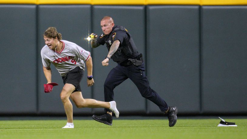 A spectator who got onto the field is chased during the ninth inning of a baseball game between the Cleveland Guardians and the Cincinnati Reds in Cincinnati, Tuesday, June 11, 2024. (AP Photo/Jeff Dean)