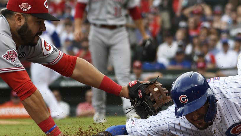 CHICAGO, ILLINOIS - MAY 25: Eugenio Suarez #7 of the Cincinnati Reds tags out Kris Bryant #17 of the Chicago Cubs at third base during the first inning at Wrigley Field on May 25, 2019 in Chicago, Illinois. (Photo by David Banks/Getty Images)