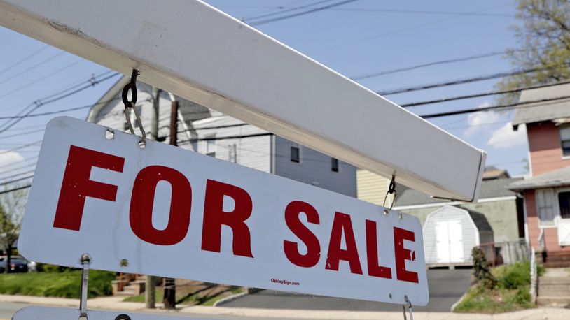 FILE - A "for sale" sign hangs from a post outside of a vacant business building in Belleville, N.J., Thursday, May 3, 2018.  The Federal Reserve on Wednesday, July 27,  raised its benchmark interest rate by a hefty three-quarters of a point for a second straight time in its most aggressive drive in three decades to tame high inflation.  By raising borrowing rates, the Fed makes it costlier to take out a mortgage or an auto or business loan.(AP Photo/Julio Cortez, File)