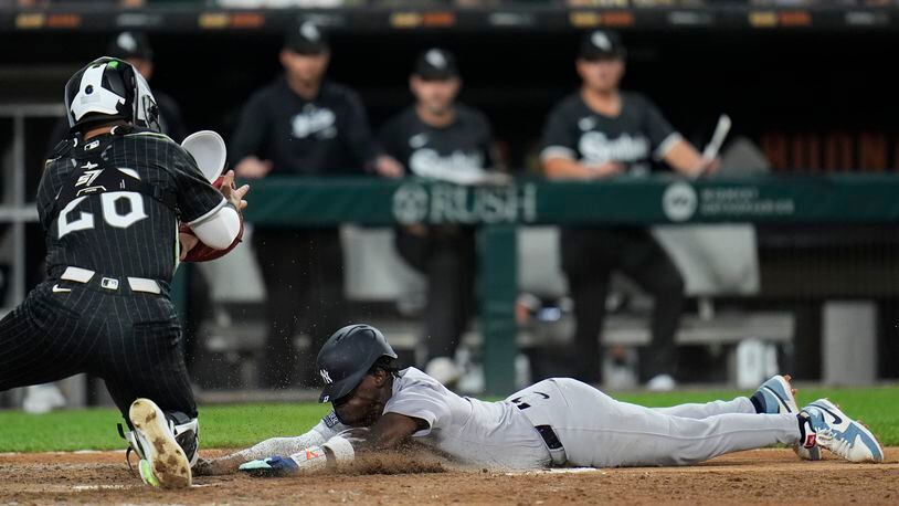 New York Yankees' Jazz Chisholm Jr., right, dives by Chicago White Sox catcher Korey Lee, left, to score on a single by Anthony Volpe during the fifth inning of a baseball game Monday, Aug. 12, 2024, in Chicago. (AP Photo/Erin Hooley)