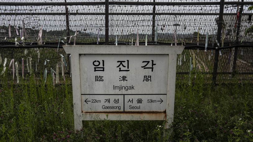 A directional sign showing the distance to North Korea's Kaesong and Seoul stands in front of fences adorned with ribbons bearing messages wishing for the reunification of the two Koreas at the Imjingak Pavilion in Paju, South Korea, Saturday, May 25, 2024. (AP Photo/Jae C. Hong)