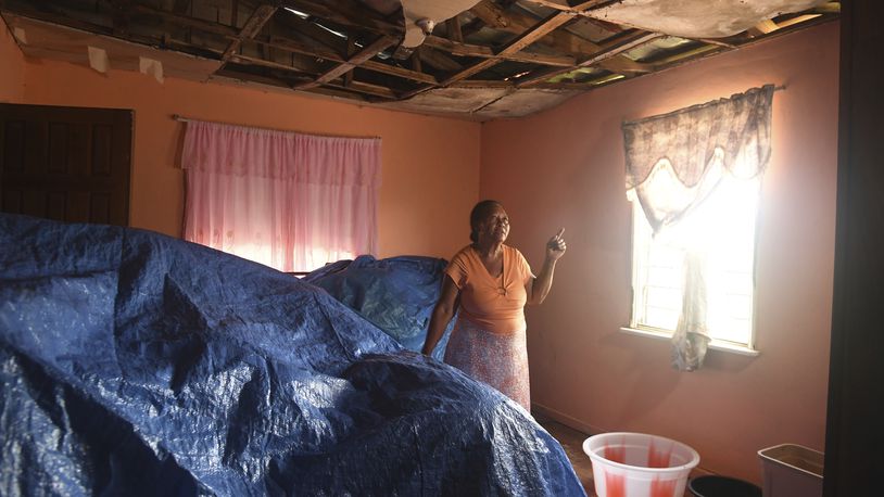 Alance Wisdom, who farms cabbage, sweet peppers and cucumbers, points to damage from Hurricane Beryl in her home on Thursday, Aug. 22, 2024, in Cross Keys, Jamaica. (AP Photo/Collin Reid)