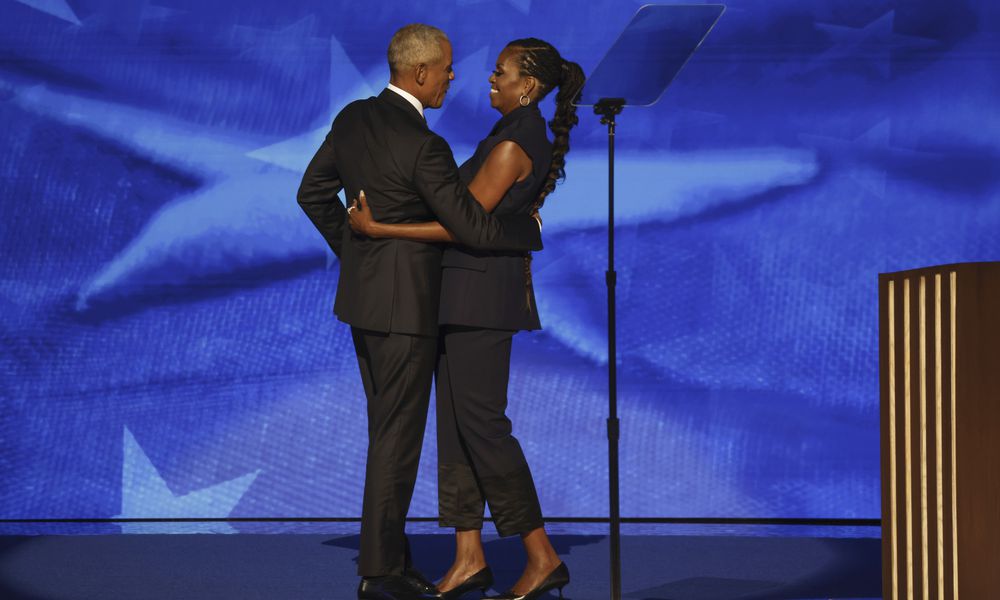 Former President Barack Obama, left, hugs former first lady Michelle Obama before speaking during Democratic National Convention in Chicago on Tuesday, Aug. 20, 2024. (Gabrielle Lurie/San Francisco Chronicle via AP)