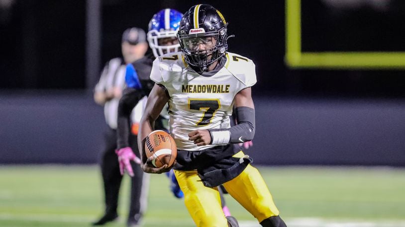 Meadowdale High School junior Jordan Brown runs past a Dunbar defender during their game on Thursday night at Dayton Welcome Stadium. The Lions won 44-14. CONTRIBUTED PHOTO BY MICHAEL COOPER