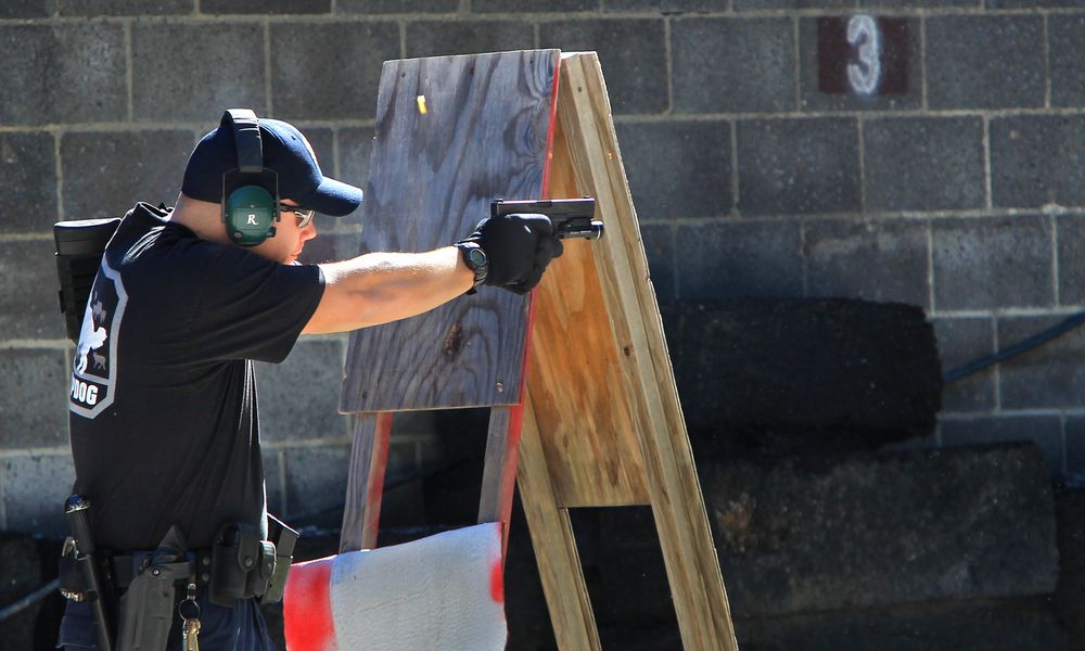 FILE—In this file photo from Oct. 8, 2013, police officer JR Lavish shoots a pistol during a police training exercise at the Eagle Creek Firearms Training Facility in Findlay, Ohio. After a 2016 shooting at Madison Local Schools in southwestern Ohio, a group of parents sued the district in September 2018 to prevent teachers from being armed without extensive training. The Ohio Supreme Court ruled Wednesday, June 23, 2021 that armed school employees must undergo an approved basic peace-officer-training program or have 20 years experience as a police officer. (Kelly Wilkinson/The Indianapolis Star via AP)