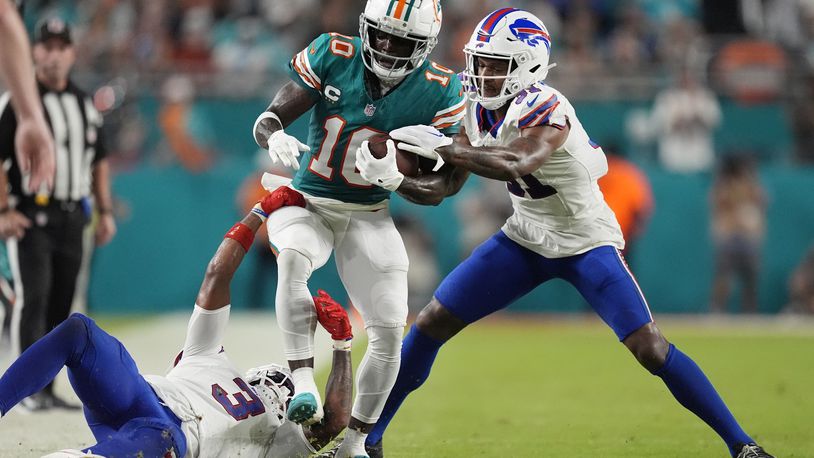 Buffalo Bills cornerback Rasul Douglas (31) and safety Damar Hamlin (3) stop Miami Dolphins wide receiver Tyreek Hill (10) during the first half of an NFL football game, Thursday, Sept. 12, 2024, in Miami Gardens, Fla. (AP Photo/Rebecca Blackwell)