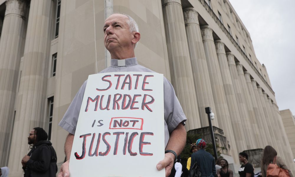 Deacon Dave Billips, with the Office of Peace and Justice with the St. Louis Archdiocese, holds a sign as he stands with protesters holding space to halt the execution of Marcellus Williams on Tuesday, Sept. 24, 2024, outside the Carnahan Courthouse in St. Louis. (Laurie Skrivan/St. Louis Post-Dispatch via AP)