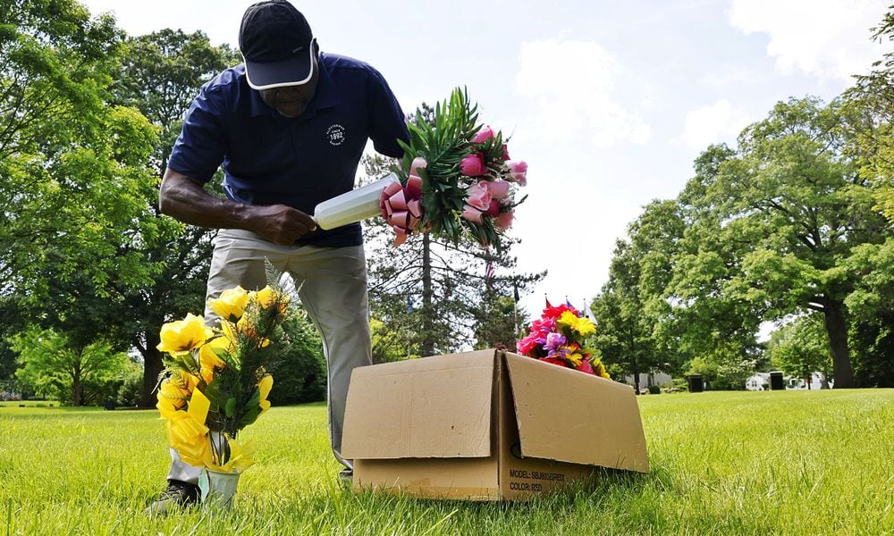 Orlando Moore places flowers at the graves of his uncles who served in various branches of military ahead of Memorial Day Tuesday, May 21, 2024 st Woodside Cemetery and Arboretum in Middletown. NICK GRAHAM/STAFF