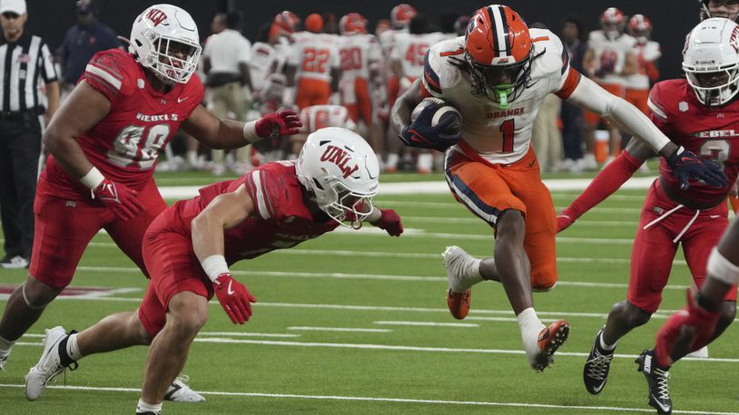 Syracuse running back LeQuint Allen (1) runs the ball by UNLV linebacker Jackson Woodard (7) in the second half during an NCAA college football game, Friday, Oct. 4, 2024, in Las Vegas. (AP Photo/Rick Scuteri)