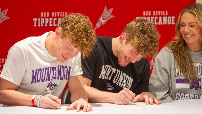 Tippecanoe football players Evan Liette (left) and Cael Liette sign letters of intent Tuesday to play at Mount Union while their mom, Kari Scott, watches. Jeff Gilbert/CONTRIBUTED