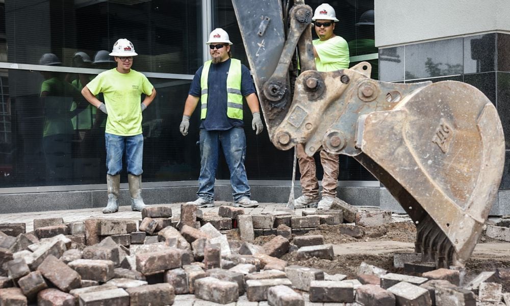 Workers replace the brick sidewalks around the Dayton Convention Center on 5th Street with concrete walkways Monday May 6, 2024. JIM NOELKER/STAFF