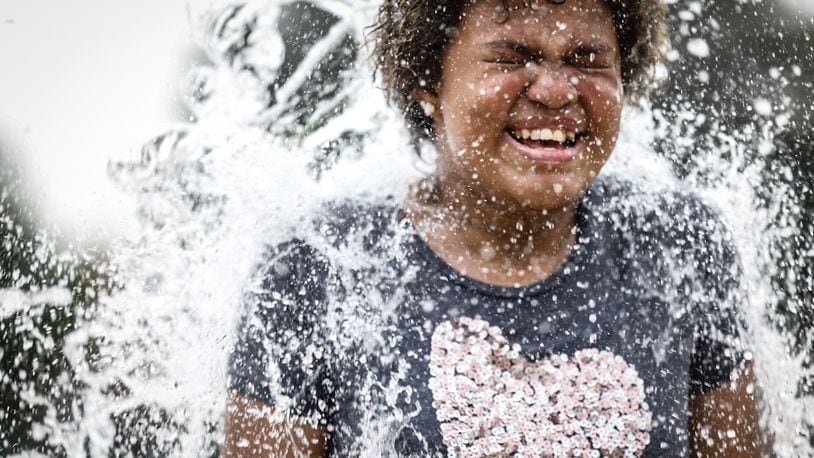 Frost Anderson, from Dayton, enjoys the splash pad at W.S. Mcintosh Park in Dayton. Temperatures are expected to reach the 90s this week. JIM NOELKER/STAFF