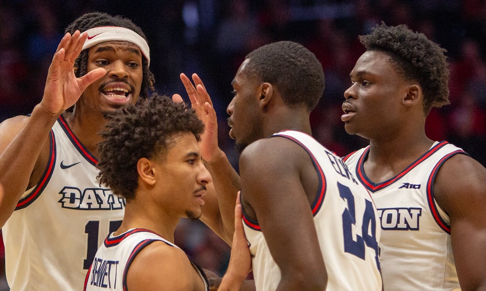 Left to right, DaRon Holmes II, Javon Bennett, Kobe Elvis and Enoch Cheeks huddle at the foul line during the first half Saturday in Dayton's 82-70 victory over Troy at UD Arena. Jeff Gilbert/CONTRIBUTED