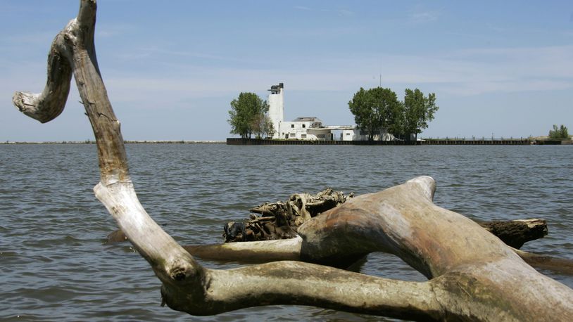 FILE - A dead tree on the Lake Erie shoreline frames the old Coast Guard lifeboat station at the mouth of the Cuyahoga River in Cleveland, May 29, 2008. Tuesday, Oct. 18, 2022, is the 50th anniversary of Congress passing the Clean Water Act to protect U.S. waterways from abuses like the oily industrial pollution that caused Ohio's Cuyahoga River to catch on fire in 1969. (AP Photo/Mark Duncan, File)