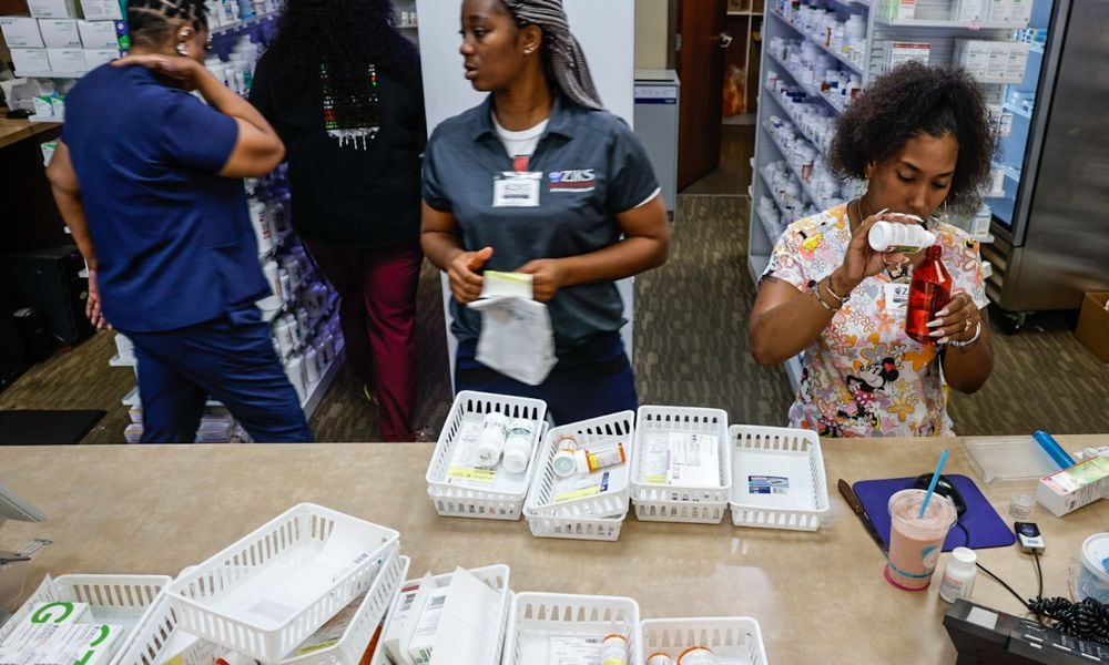 Pharmacy technicians for Ziks Pharmacy on West Third Street Jasmine Woodard, right and Joy Duaka, center, prep medications at the store on Monday, July 1, 2024. The closing of many pharmacies around Dayton is making it harder for residents to get their medications and harder for the pharmacies left to meet growing demands. JIM NOELKER/STAFF