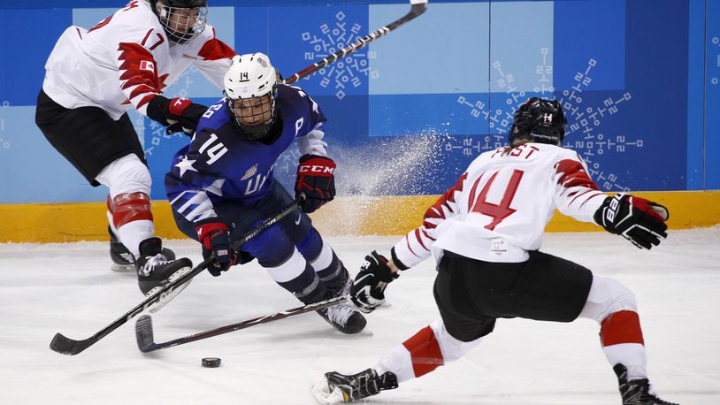 FILE - Brianna Decker (14), of the United States, skates with the puck away from Bailey Bram (17) and Renata Fast (14), of Canada, during the first period of the women's gold medal hockey game at the 2018 Winter Olympics in Gangneung, South Korea, Thursday, Feb. 22, 2018. (AP Photo/Jae C. Hong, File)