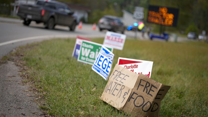 A makeshift cardboard sign leans up against campaign posters near a relief center on Thursday, Oct. 3, 2024, in Vilas, N.C. in the aftermath of hurricane Helene. In the final weeks of the presidential election, people in North Carolina and Georgia, influential swing states, are dealing with more immediate concerns: recovering from Hurricane Helene. (AP Photo/Chris Carlson)