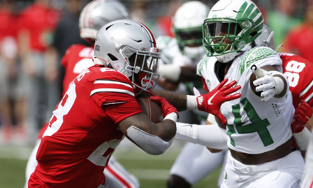 Ohio State running back Miyan Williams, left, tries to run past Oregon defensive lineman Bradyn Swinson during the first half of an NCAA college football game Saturday, Sept. 11, 2021, in Columbus, Ohio. Oregon beat Ohio State 35-28. (AP Photo/Jay LaPrete)