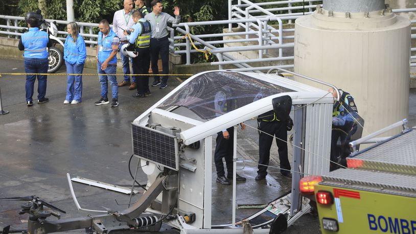 A cable car lays on the ground after it fell in Medellin, Colombia, Wednesday, June 26, 2024. At least one person was killed and 12 others were injured when the cable car collapsed while approaching a station, local authorities said. (AP Photo/Fredy Amariles)