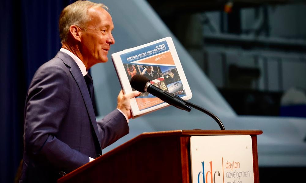 Jeff Hoagland, president and chief executive of the Dayton Development Coalition, holding a copy of the coalition's strategic plan. MARSHALL GORBY/STAFF