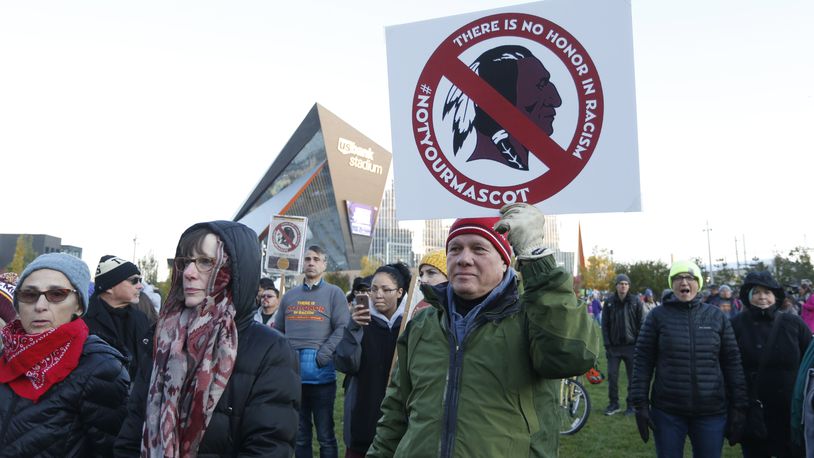 FILE - In this Oct. 24, 2019, file photo, Native American leaders protest against the Redskins team name and logo outside U.S. Bank Stadium before an NFL football game between the Minnesota Vikings and the Washington Redskins in Minneapolis. Many Native Americans thought a bitter debate over the U.S. capital's football mascot was over when the team became the Washington Commanders. The original logo was designed by a member of the Blackfeet Nation. Now a white Republican U.S. senator from Montana is reviving the debate by blocking a bill funding the revitalization of the team's stadium unless the NFL and the Commanders bring back the former logo in some form. (AP Photo/Bruce Kluckhohn, File)