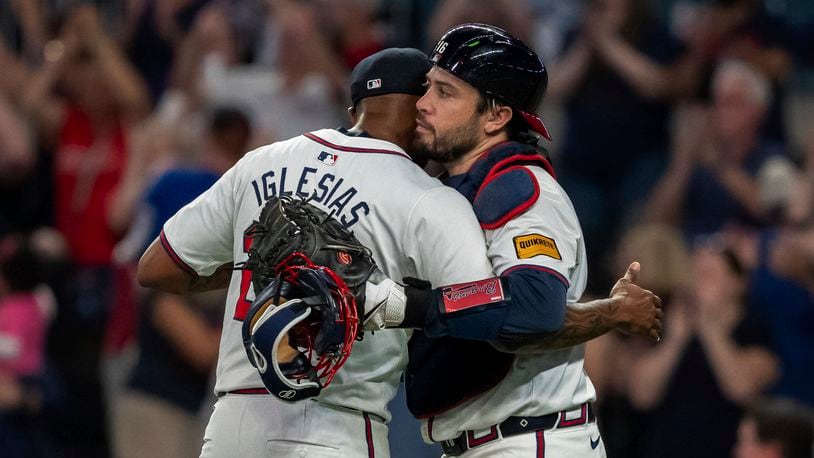 Atlanta Braves pitcher Raisel Iglesias, left, celebrates the win with catcher Travis d'Arnaud, right, following the ninth inning of a baseball game against the New York Mets, Tuesday, Sept. 24, 2024, in Atlanta. (AP Photo/Jason Allen)