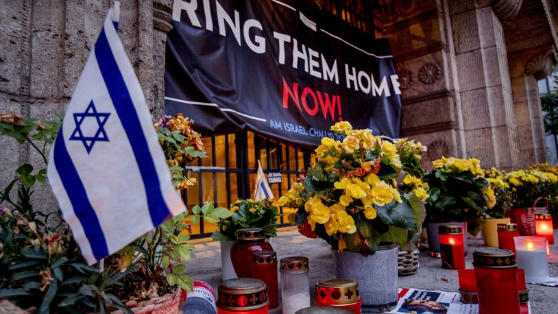 Candles and flowers are laid at the entrance of the synagogue to mark the first anniversary of the Hamas attack on Israel, Frankfurt, Germany, Monday, Oct. 7, 2024. (AP Photo/Michael Probst)