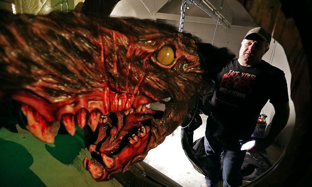 Fred Messaros pushes a giant monster rat through the hole is will come through when the Face Your Fears Hotel of Terror opens for the season. BILL LACKEY/STAFF