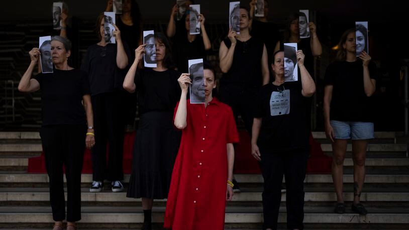 Relatives and supporters of Israeli hostages held by Hamas in Gaza hold photos of their loved ones during a performance calling for their return in Tel Aviv, Israel, Thursday, May 23, 2024. (AP Photo/Oded Balilty)