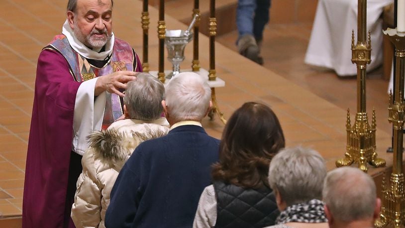 Parishioners at St. Raphaels Catholic Church receive ashes on their foreheads during Ash Wednesday services. Ash Wednesday marks the first day of Lent. BILL LACKEY/STAFF