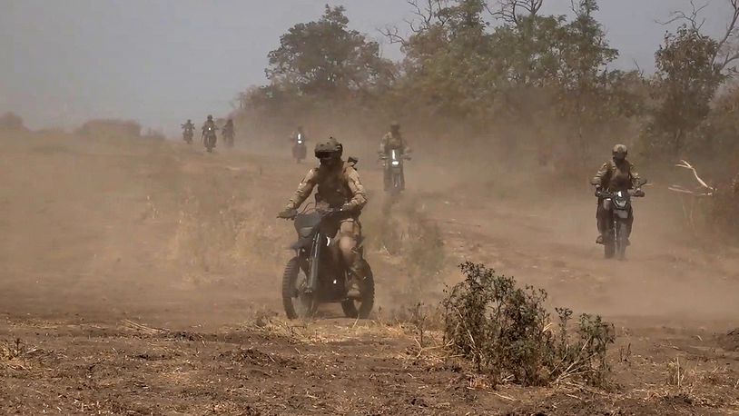 In this photo taken from video released by Russian Defense Ministry Press Service on Monday, Aug. 12, 2024, marine assault team members ride motorcycles toward Ukrainian position at an undisclosed location. (Russian Defense Ministry Press Service photo via AP)