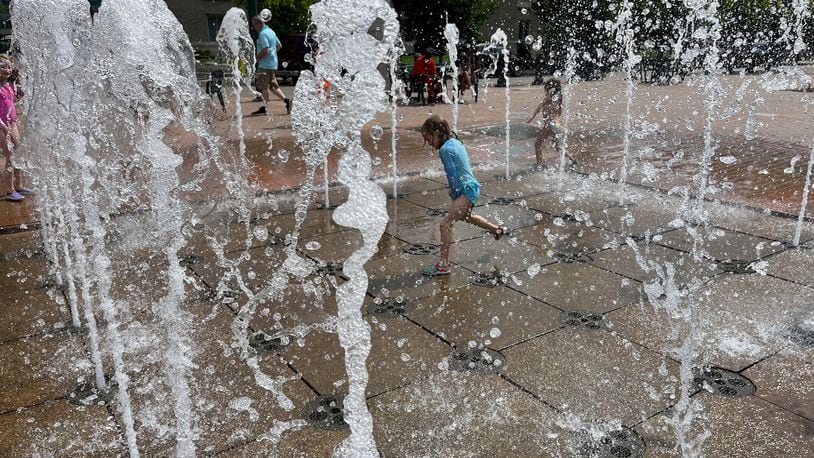 A young girl plays in the fountain at RiverScape MetroPark in downtown Dayton on Sunday, July 9, 2023. CORNELIUS FROLIK / STAFF