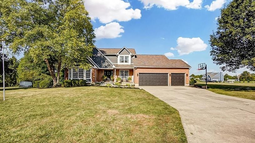 The brick and vinyl two story has a covered front porch and attached three car garage.