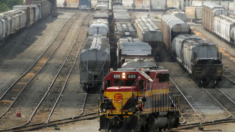 A worker climbs aboard a locomotive at a CPKC rail yard Wednesday, Aug. 21, 2024, in Kansas City, Mo. (AP Photo/Charlie Riedel)