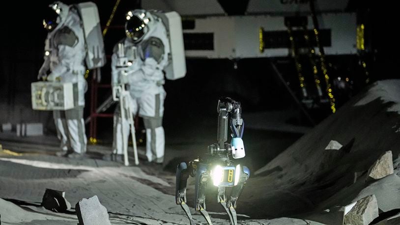 Astronauts Thomas Pesquet of France and Matthias Maurer of Germany and their canine-like robot demonstrate their training in lunar surface simulating conditions for future moon missions, like the Artemis lunar exploration program led by NASA, at the opening of the new LUNA facility at the European Astronaut Center in Cologne, Germany, Wednesday, Sept. 25, 2024. (AP Photo/Martin Meissner)