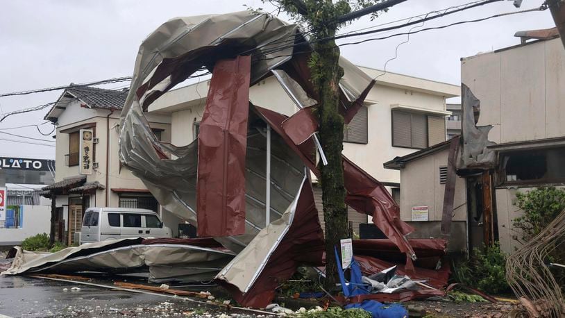 A metal object blown away by strong winds of a typhoon is caught on a power line in Miyazaki, western Japan, Thursday, Aug. 29, 2024. (Kyodo News via AP)