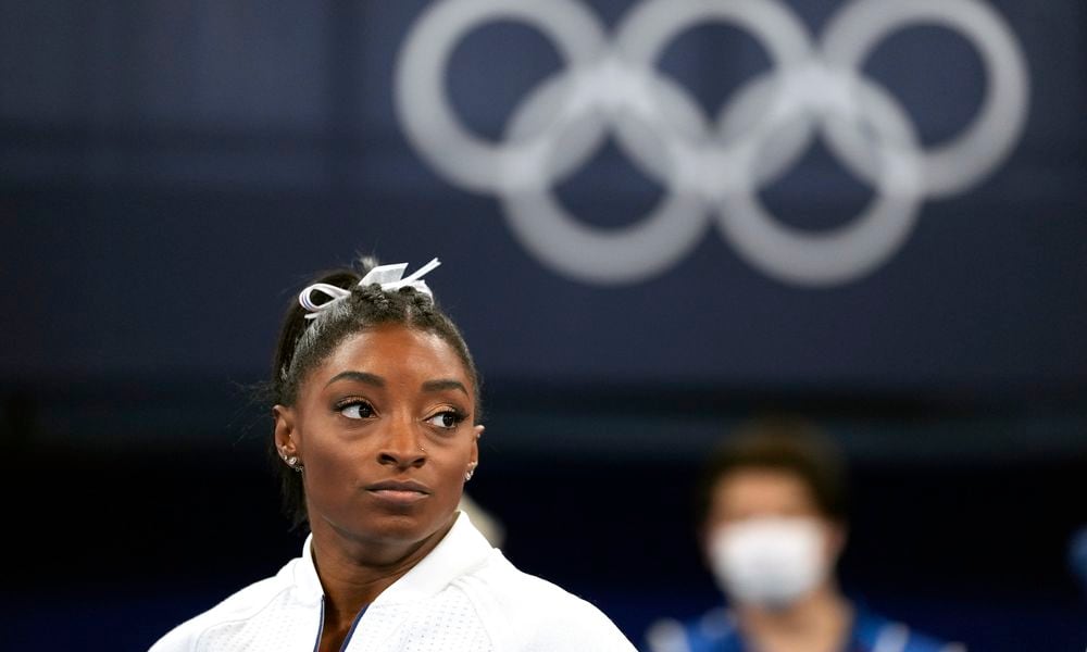 FILE - In this July 27, 2021 file photo, Simone Biles, of the United States, watches gymnasts perform after she exited the team final at the 2020 Summer Olympics, in Tokyo. Biles, who redefined excellence in gymnastics and picked up seven Olympic medals along the way, drew attention and, from some, criticism by pulling out of events in Tokyo because of a mental block that made her afraid to attempt certain dangerous moves. (AP Photo/Ashley Landis, File)