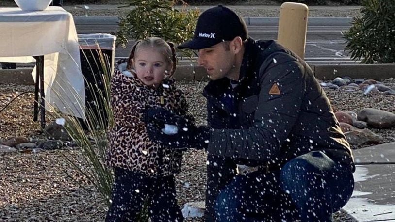 Quinn Walker plays in the snow with her father, Adam Walker, on Friday morning.