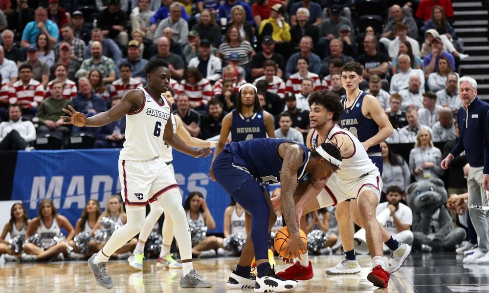 Dayton's Enoch Cheeks and Nate Santos force a turnover against Nevada in the first round of the NCAA tournament on Thursday, March 21, 2024, at the Delta Center in Salt Lake City, Utah. David Jablonski/Staff